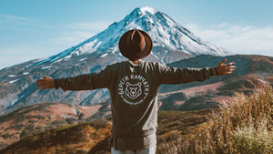 man with arms spread appreciating a mountain view