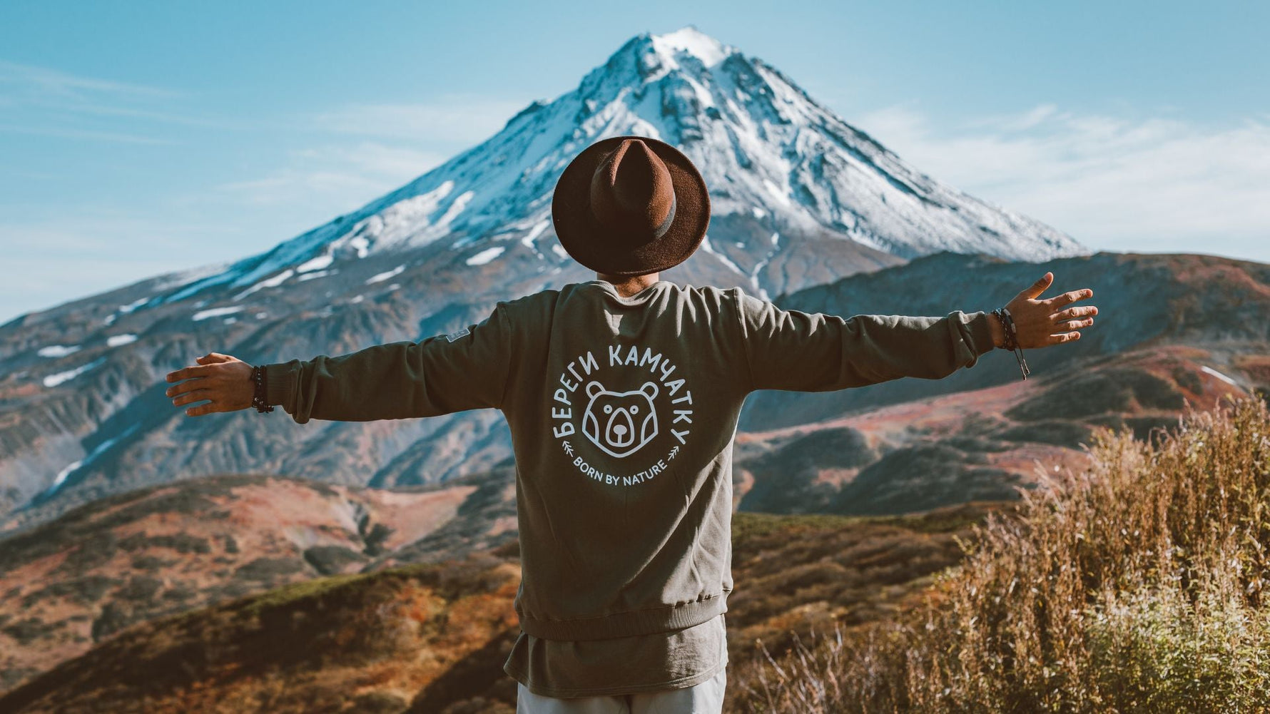 man with arms spread appreciating a mountain view