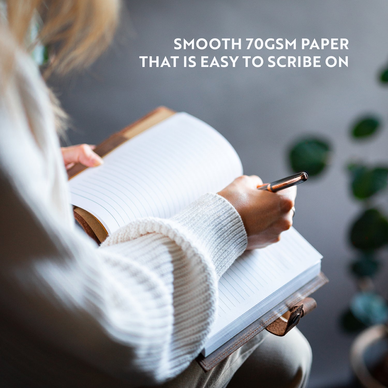 woman writing with a pen on lined paper journal