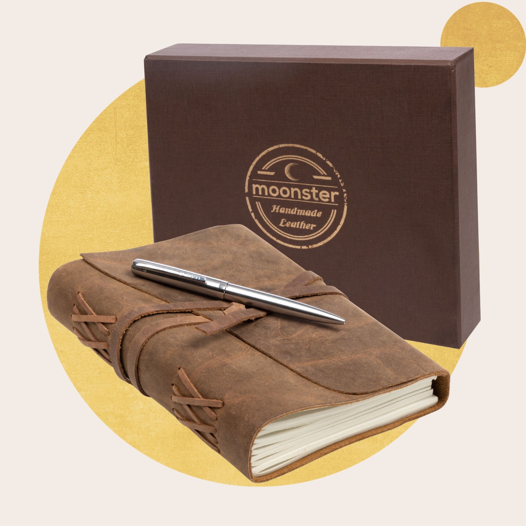 Brown leather notebook with a pen and Moonster branding on a beige background
