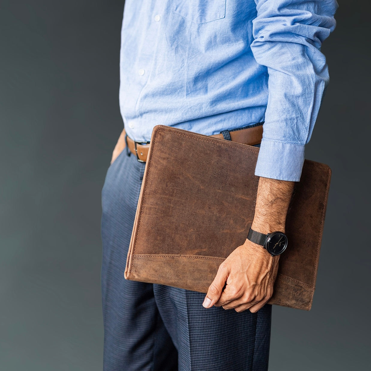 man holding a brown leather portfolio