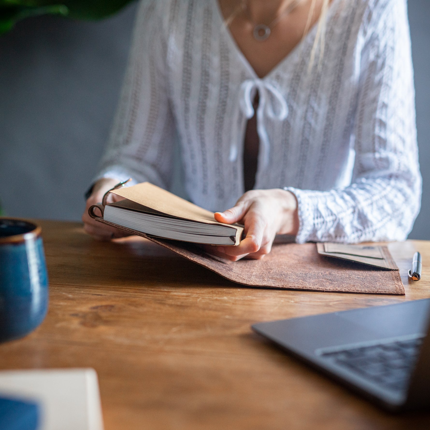 woman holding paper refills for leather journal by Moonster