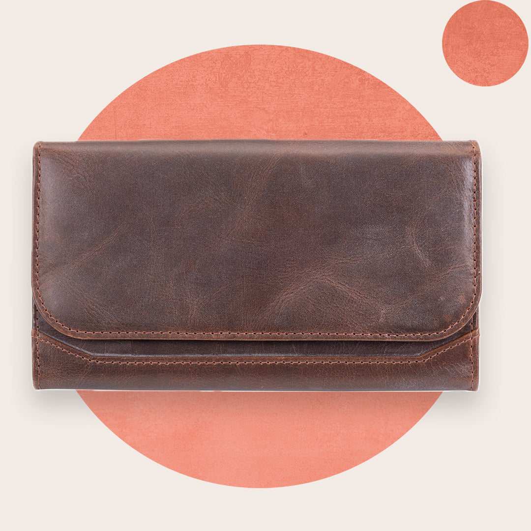 A brown leather women's wallet with a flap closure, displayed against an orange background.