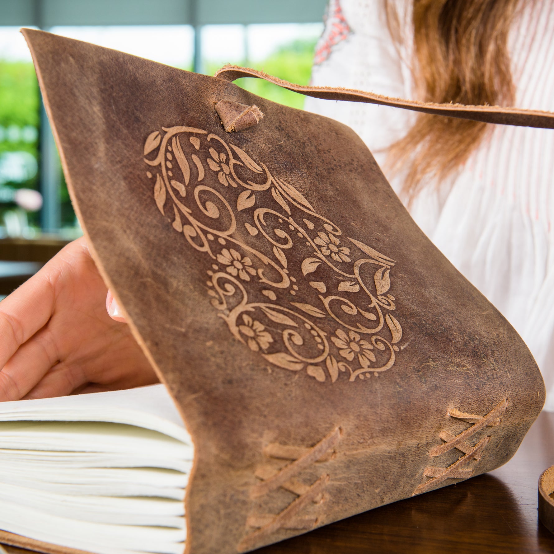 Woman opening a Leather Heart Journal