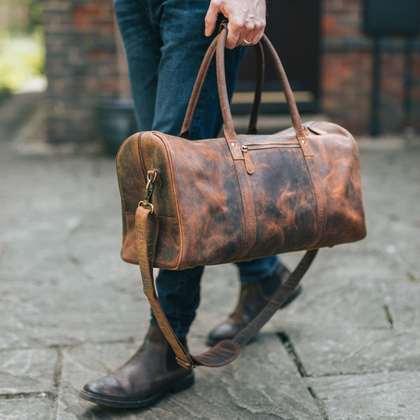 Man holding a Leather Duffle Bag